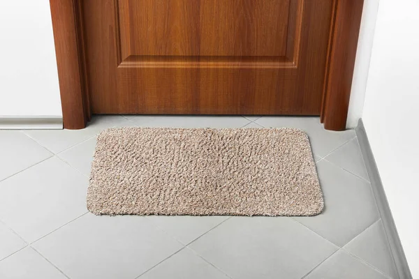 Clean door mat on floor near entrance