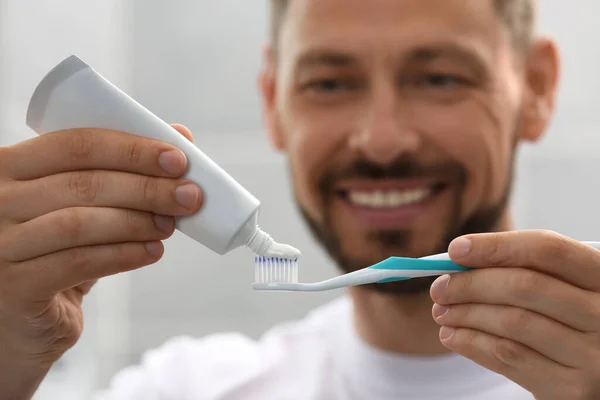 Man Applying Toothpaste Brush Blurred Background Focus Hands — Stock Photo, Image