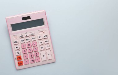 Işık arka planında pembe hesap makinesi, üst görünümde. Metin için boşluk