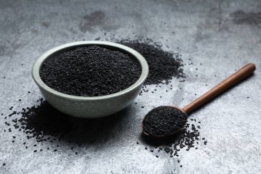 Gri masada siyah susamlı kase ve kaşık.