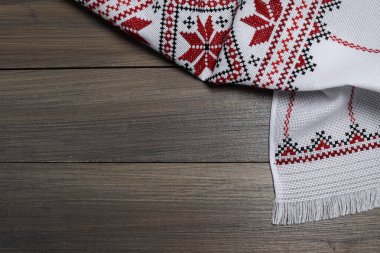 Beautiful rushnyk on wooden table, top view with space for text. Ukrainian national embroidery