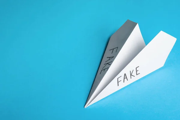 Paper Plane Words Fake Light Blue Background Top View Space — Φωτογραφία Αρχείου