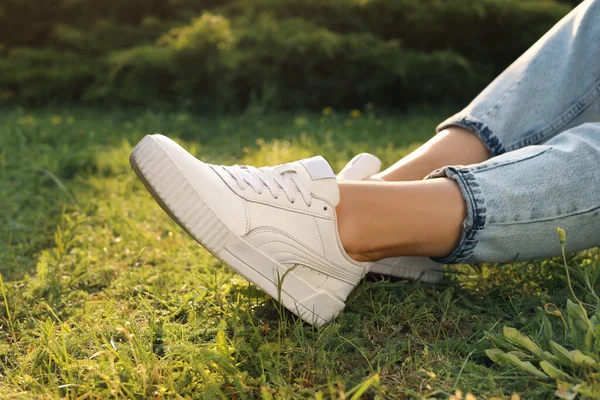Woman Jeans White Shoes Relaxing Green Grass Closeup — Φωτογραφία Αρχείου