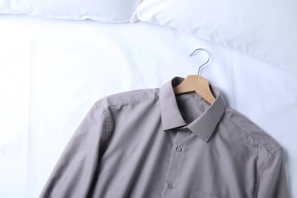 Stylish shirt on bed, top view. Dry-cleaning service