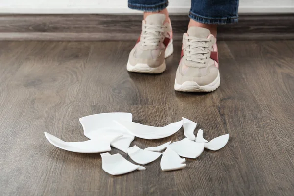Woman Sneakers Standing Broken Plate Floor Indoors Closeup — Stock Photo, Image