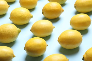 Açık mavi arka planda bir sürü taze limon