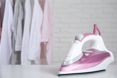 Modern ütü, içinde temiz giysiler olan rafın yanındaki masada, metin için yer var.