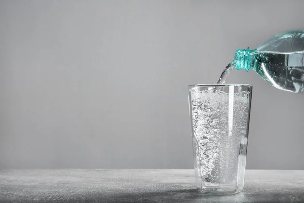Pouring Soda Water Bottle Glass Grey Table Space Text — Zdjęcie stockowe