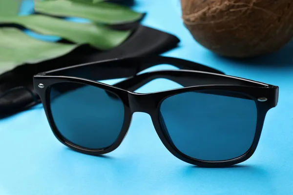 Stylish Sunglasses Black Cloth Bag Light Blue Background Closeup — Stockfoto