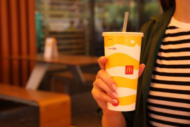 MYKOLAIV, UKRAINE - 11 Ağustos 2021: Dışarıdaki kafede soğuk McDonald 's içen kadın, yakın plan