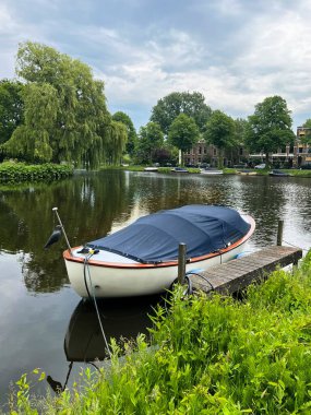 Çevresi yeşilliklerle çevrili güzel bir şehir kanalı manzarası.