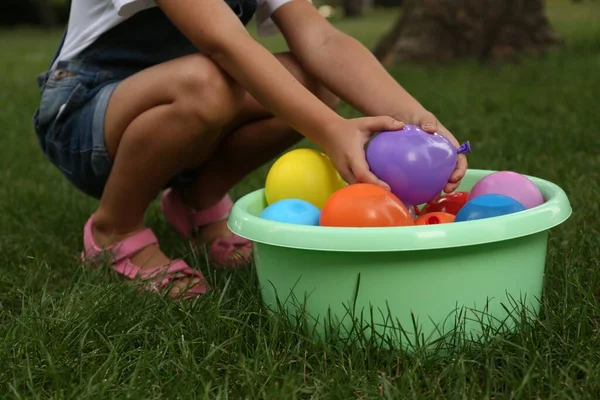 Kleines Mädchen Mit Wasserbomben Auf Grünem Gras Nahaufnahme — Stockfoto