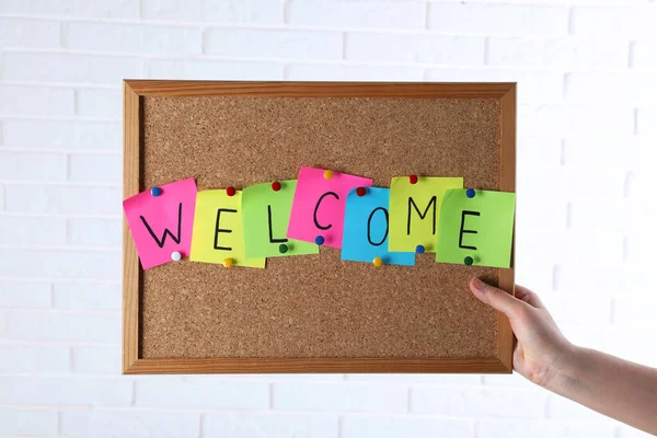 Woman Holding Corkboard Word Welcome White Brick Wall Closeup — Stock Photo, Image