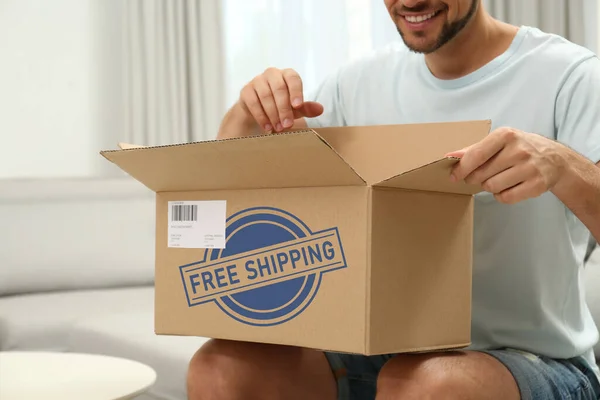 Happy Man Opening Parcel Sofa Home Closeup Free Shipping — Foto de Stock