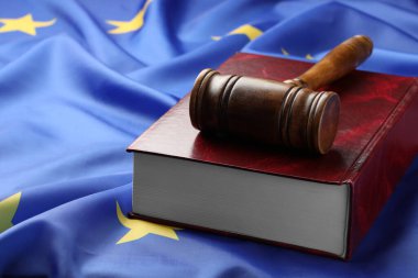 Wooden judge's gavel and book on flag of European Union, space for text