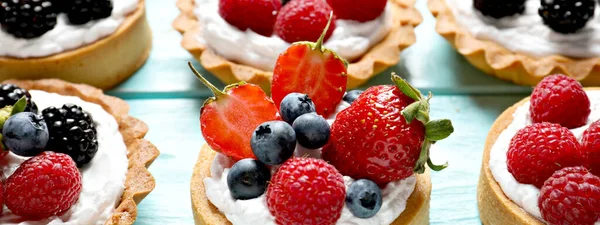 Delicious Tartlets Fresh Berries Light Blue Wooden Table Closeup Banner — Stockfoto