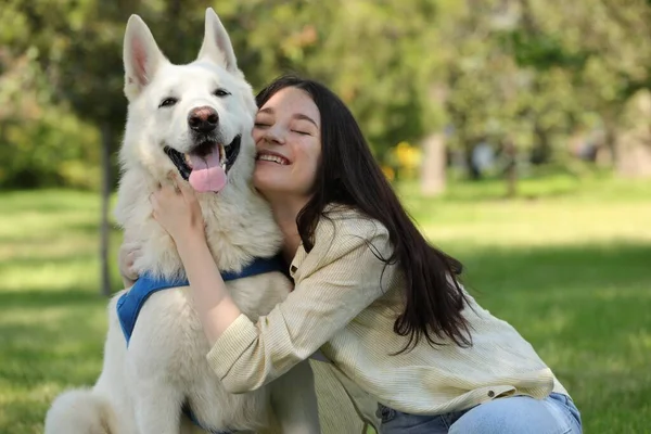 ティーン女の子抱擁彼女の白いですスイスシェパード犬で公園 — ストック写真