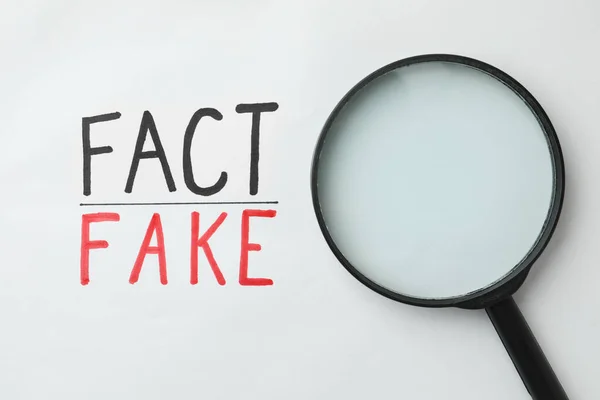 Magnifying Glass Words Fact Fake Written White Background Top View — Fotografia de Stock