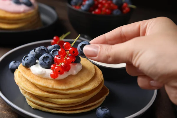 Woman Decorating Tasty Pancakes Natural Yogurt Blueberries Red Currants Wooden — Fotografia de Stock