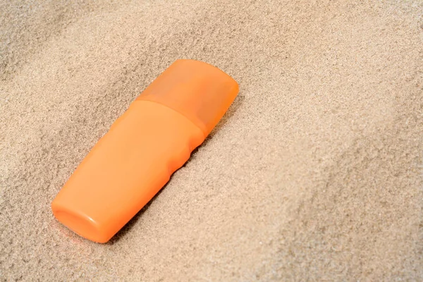 Bottle with sun protection spray on sandy beach, closeup. Space for text