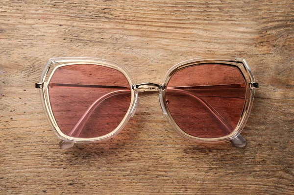 New Stylish Sunglasses Wooden Table Top View — Zdjęcie stockowe