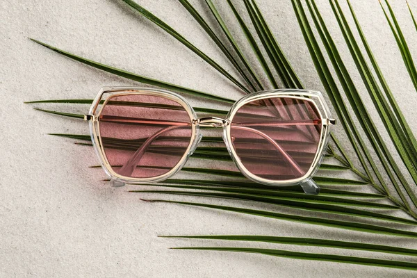 Stylish Sunglasses Palm Leaf Sand Top View — Fotografia de Stock