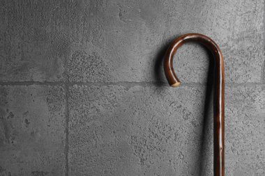 Gri taş arka planda zarif tahta baston, yakın plan. Metin için boşluk