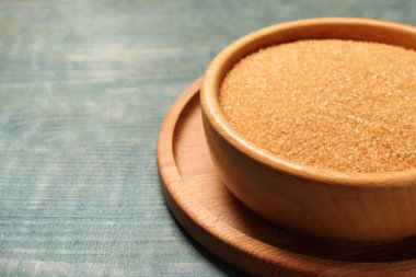 Açık mavi ahşap masada kahverengi şeker, yakın plan. Metin için boşluk