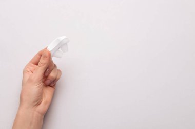 Açık gri arka planda horlama önleyici cihaz tutan bir kadın. Metin için boşluk