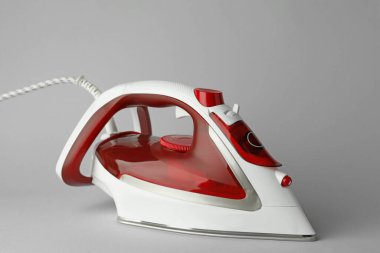 Açık gri arkaplanda modern bir ütü. Ev aletleri