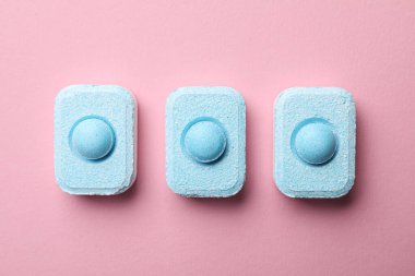 Su yumuşatıcı tabletler pembe arka planda, düz yatıyordu