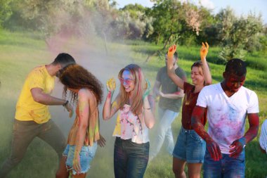 Mutlu arkadaşlar açık havada renkli pudra boyalarıyla eğleniyorlar. Holi festivali kutlaması