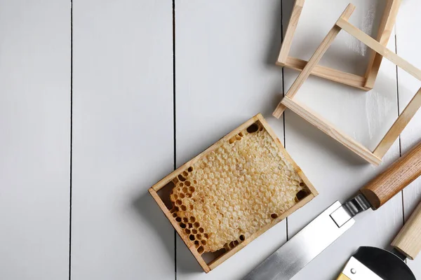 ハニカムフレームと白い木製のテーブル フラットレイアウト上の養蜂ツール テキストのスペース — ストック写真