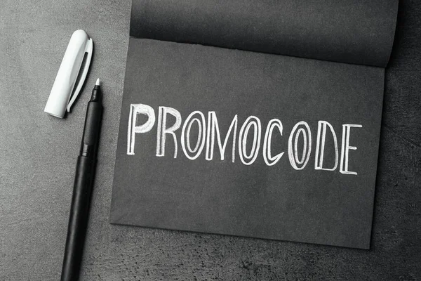 Notitieboek Met Woorden Promo Code Witte Stift Grijze Tafel Plat — Stockfoto