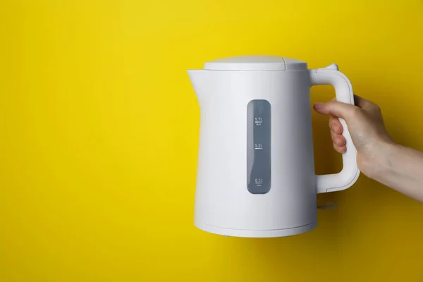 Woman Holding Modern Electric Kettle Yellow Background Closeup Space Text — 스톡 사진