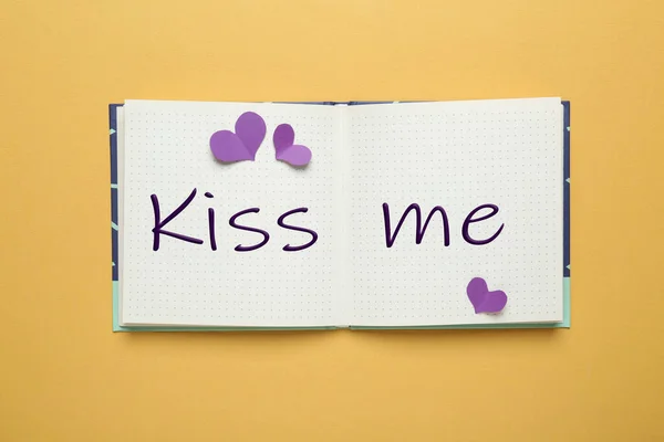 Open Notebook Phrase Kiss Paper Hearts Pale Orange Background Top — Stockfoto