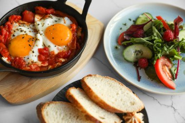 Lezzetli Shakshouka beyaz masada servis yapıyor. Geleneksel Arapça yemek