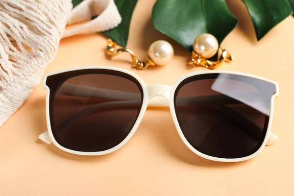New Stylish Elegant Sunglasses Beautiful Earrings Beige Background Closeup — Photo