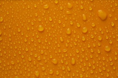 Parlak turuncu arka planda birçok su damlası