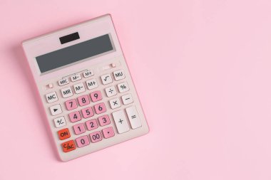 Pembe arka planda modern hesap makinesi, üst görünüm. Metin için boşluk