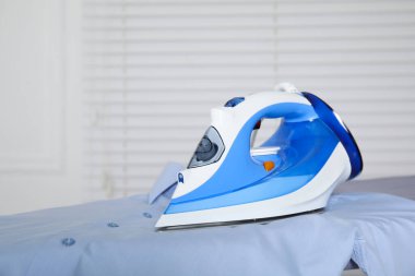 Kapalı alanda modern ütü ve temiz gömlek, metin için boşluk