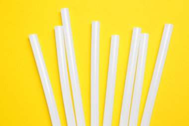 Many glue gun on yellow background, flat lay