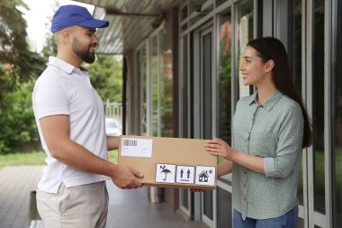 Dışarıdaki kuryeden paket alan kadın. Teslimat servisi