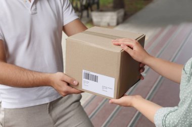 Dışarıdaki kuryeden paket alan kadın, yakın plan.