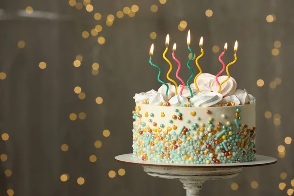Prachtige Verjaardagstaart Met Brandende Kaarsen Standaard Tegen Feestelijke Lichtjes Ruimte — Stockfoto