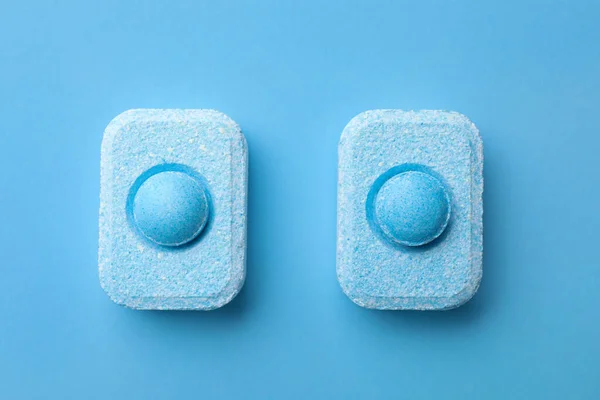 Water softener tablets on light blue background, flat lay