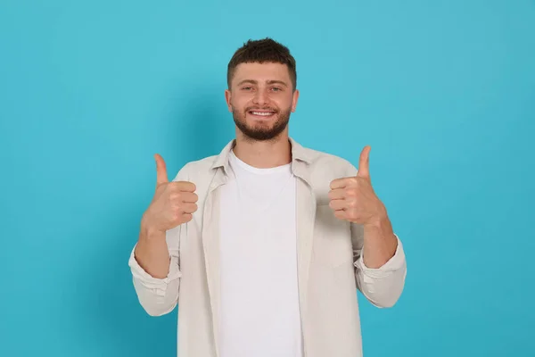 Young Man Showing Thumbs Light Blue Background — Stok fotoğraf