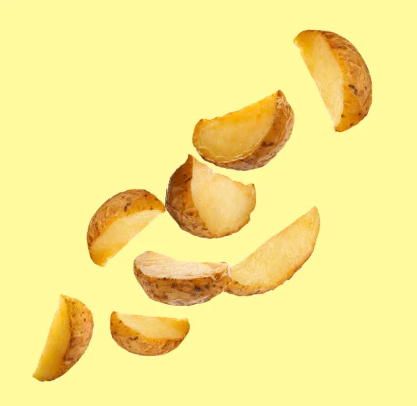Tasty Baked Potatoes Falling Beige Background — Stockfoto