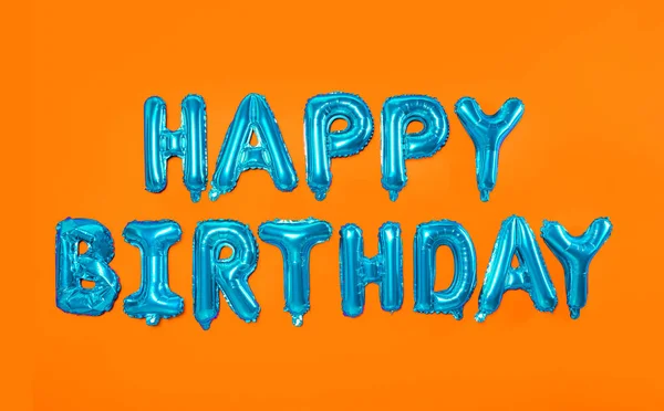 Phrase Happy Birthday Made Blue Foil Balloon Letters Orange Background — стоковое фото