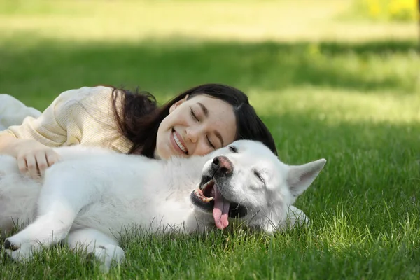 在公园的绿草上 少女和她的瑞士牧羊犬躺在一起 — 图库照片